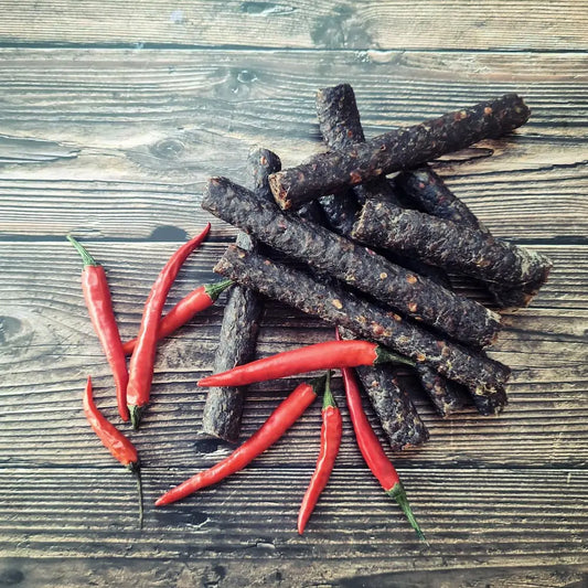 Droëwors chilli—thin sticks of air-dried beef sausage with a clean snap and gentle chilli heat, served on a snack board