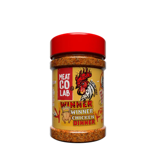 Angus & Oink Winner Winner Chicken Dinner seasoning tub beside golden roasted chicken thighs with lemon and herbs