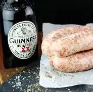 Beef and Guinness sausages browned in a pan, served with buttery mash and stout onion gravy