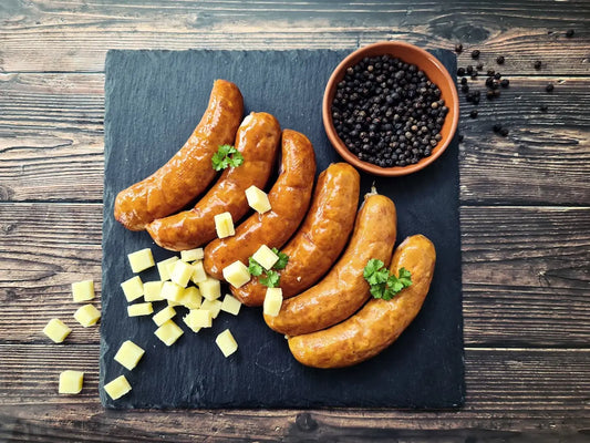 Cheese Russian sausages browned in a pan, sliced to show melty cheese pockets with garlicky juices