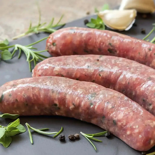 Lincolnshire sausages—coarse-ground, herb-led links browned in a pan and served with mash and onion gravy