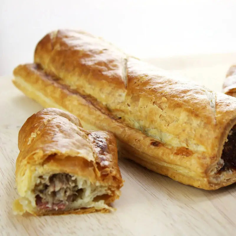 Old English sausage roll baked to a golden flaky crust, sliced to show herby pork filling